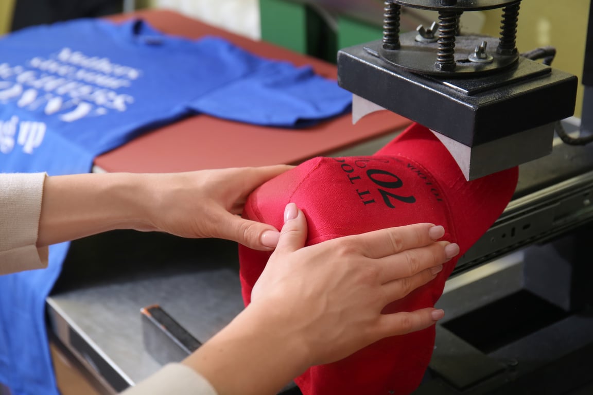 Young Woman Printing on Cap at a Printing Shop 